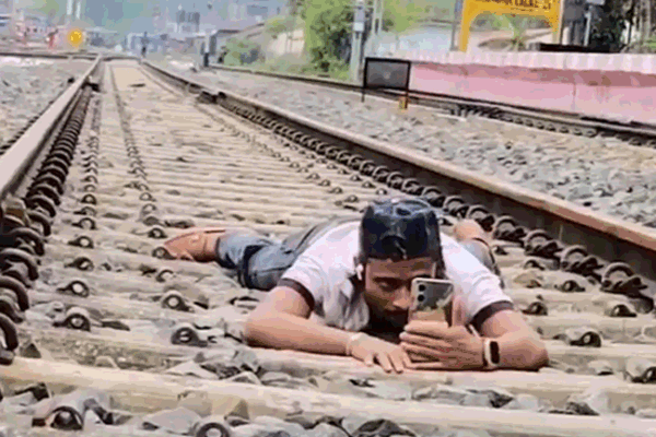 A Man Lay Down Between The Tracks to Go Viral Hilakandi Police Assam Imranbhai Assam | Person lying among the tracks to go viral: made a video of the train passing above, arrested; The accused said- video was edited